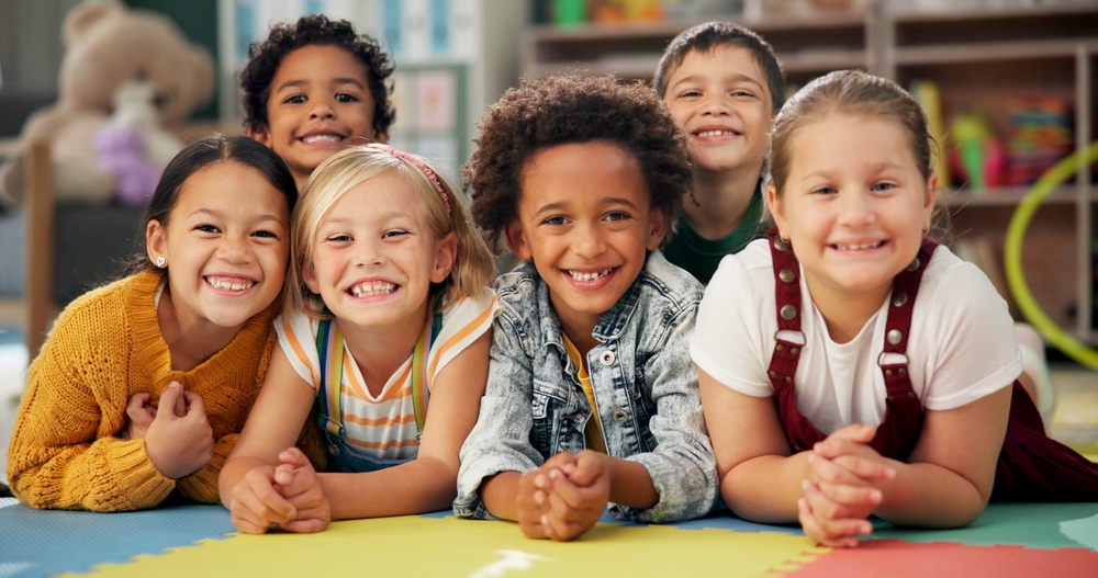 Group of smiling children lying on play mat at Child Expert Network consultation room